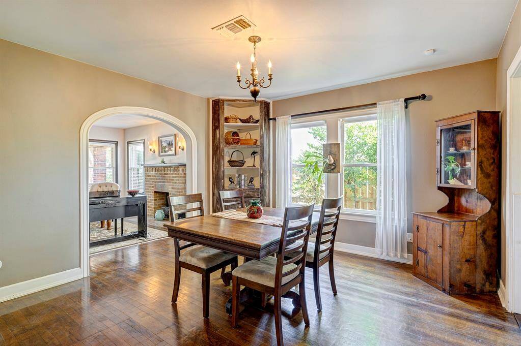 Views of side yard brighten the dining room with its arched doorway to living rm and built in cabinet.