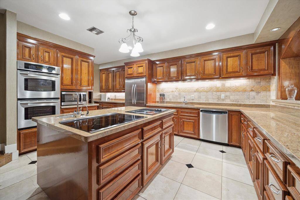Spacious kitchen featuring a large island with a built-in cooktop.