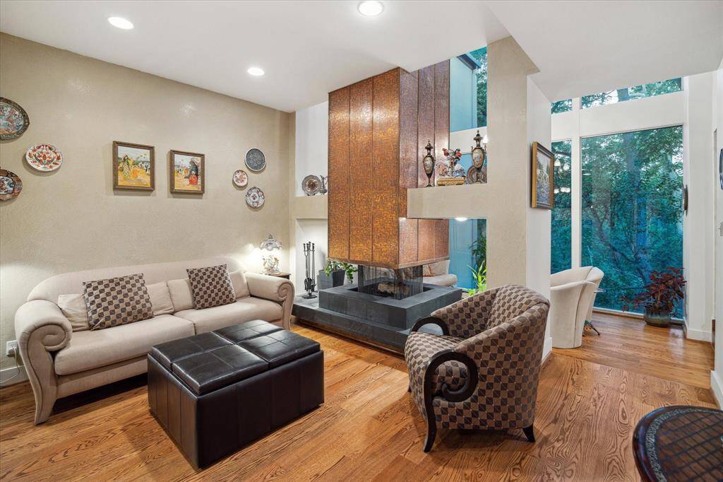 Another angle of the breakfast room showcasing the custom 360-degree fireplace with a soaring copper plated chimney and picture