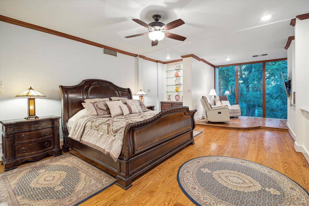 Expansive primary suite with sitting area, stone clad bathroom, and two walk-in closets.