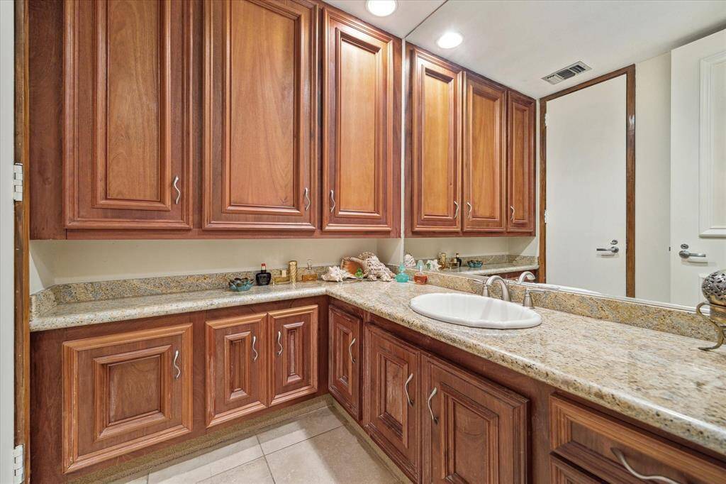 Elegant Hollywood-style bathroom vanity with rich wooden cabinets and sleek granite countertops.