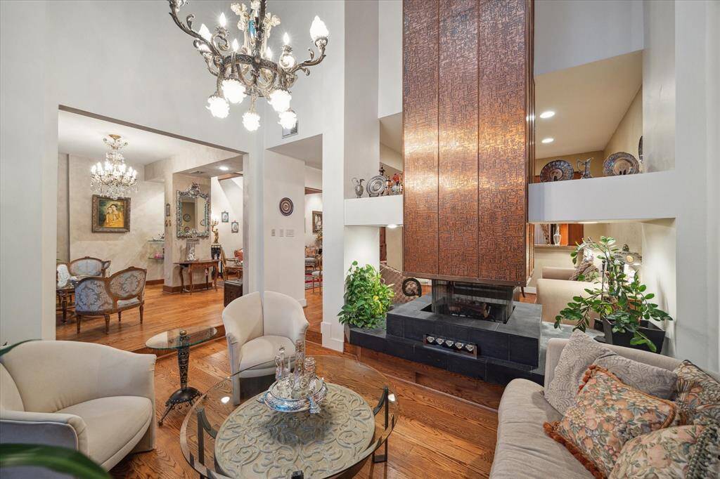Experience the warmth and elegance of the family room featuring a stunning custom 360-degree fireplace.
