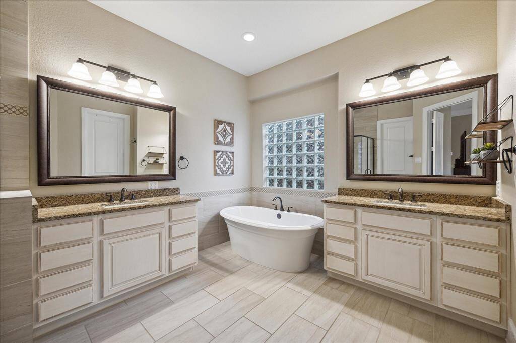 Stand alone soaking tub, double sinks, beautiful white cabinetry, massive walk in closet with built ins, separate custom shower make this space a spa like retreat!