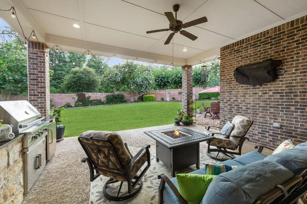 Enjoy your morning cup of coffee on this extended covered patio surrounded by luscious landscaping and beautiful mature trees!