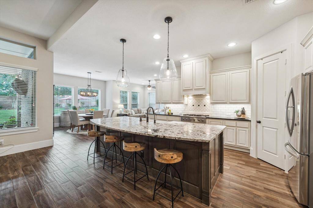 Custom kitchen open to the sunroom, breakfast area, and family room with tons of natural light flowing in from the wall of windows providing gorgeous views of the backyard every which way you turn!