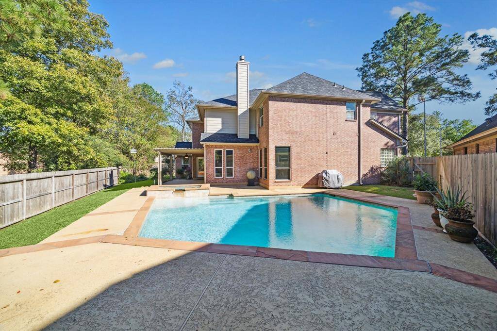 Spacious backyard with a private in-ground pool and patio, surrounded by a privacy fence and mature trees. Pool was re-plastered in February 2025.