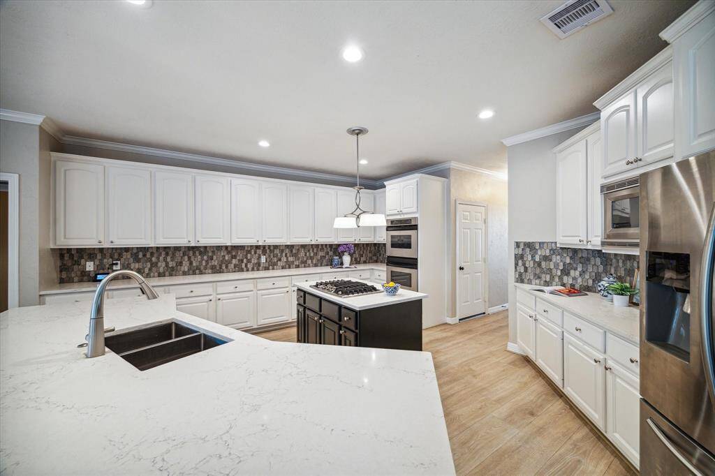 Updated kitchen offers double ovens, gas cook-top, quartz counter-tops, stainless undermount sink, updated back splash and painted Kentmoore cabinets. Refrigerator to remain.