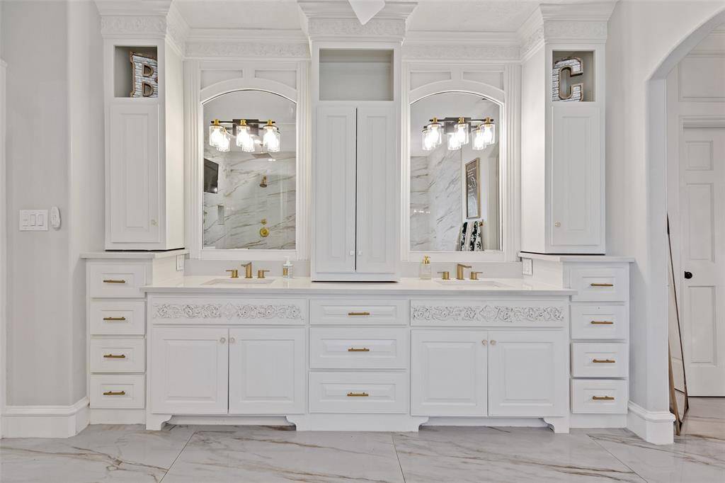 Cabinetry work in this house is simply fabulous. Primary bath is complete with double sinks, stunning custom mirrors, and plenty of cabinets for storage.