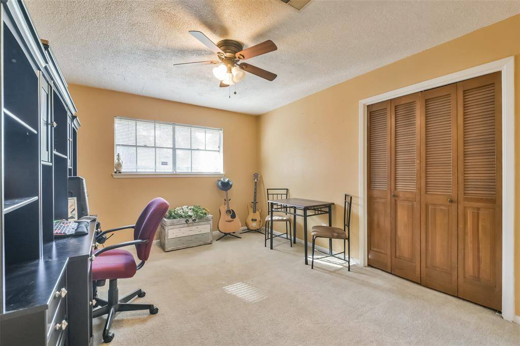 Versatile second bedroom featuring soft carpeting, a large window for natural light, and a ceiling fan for added comfort.