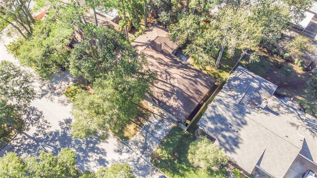 This aerial perspective highlights 1805 Twila Lane nestled among mature trees, offering a tranquil and shaded setting. The surrounding neighborhood showcases well-maintained homes, adding to the property's inviting charm.