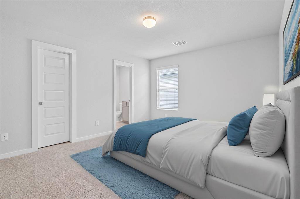 This secondary bedroom features high ceilings, lighting, custom paint, plush carpet, ample closet space, large window with blinds, and private access to a secondary bathroom!