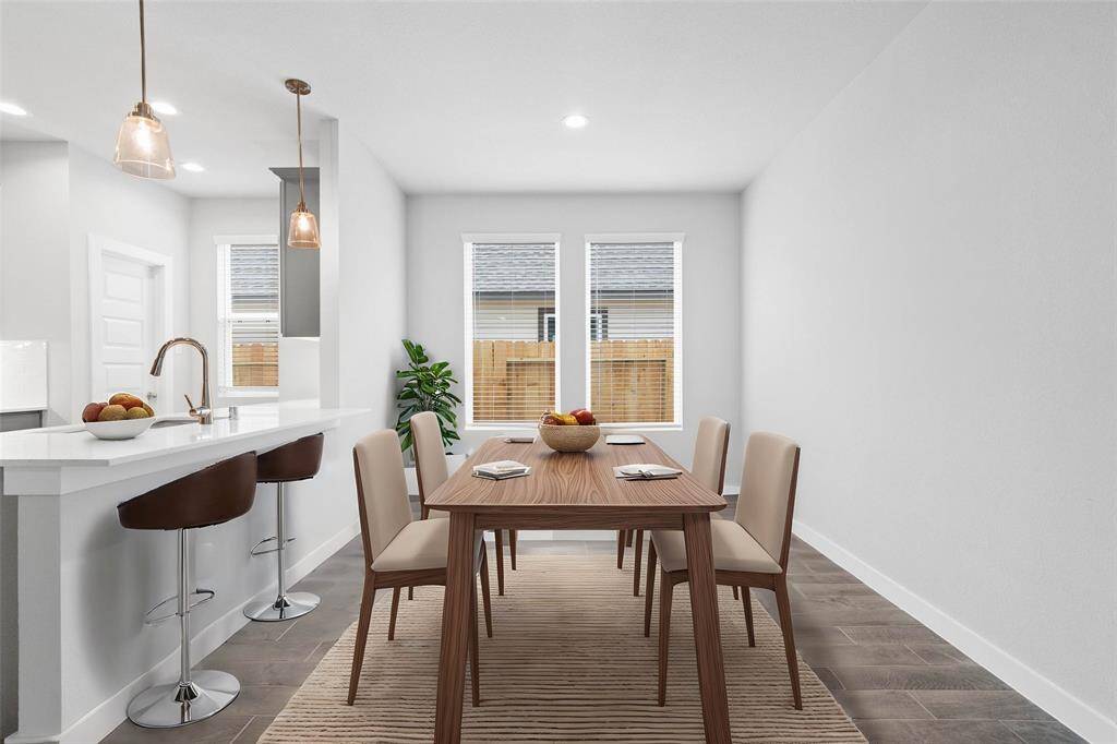 Make memories gathered around the table with your family and friends! This dining room features high ceilings, recessed lighting, large windows, and gorgeous wood look tile flooring!