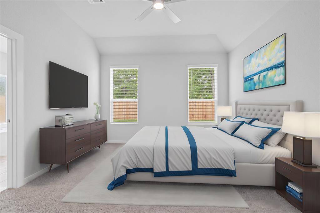 What a wonderful place to come home to, this stunning primary suite greets you with plush carpet, warm custom paint, high ceiling with ceiling fan, and lovely windows allowing in natural light brightening up this spacious bedroom.