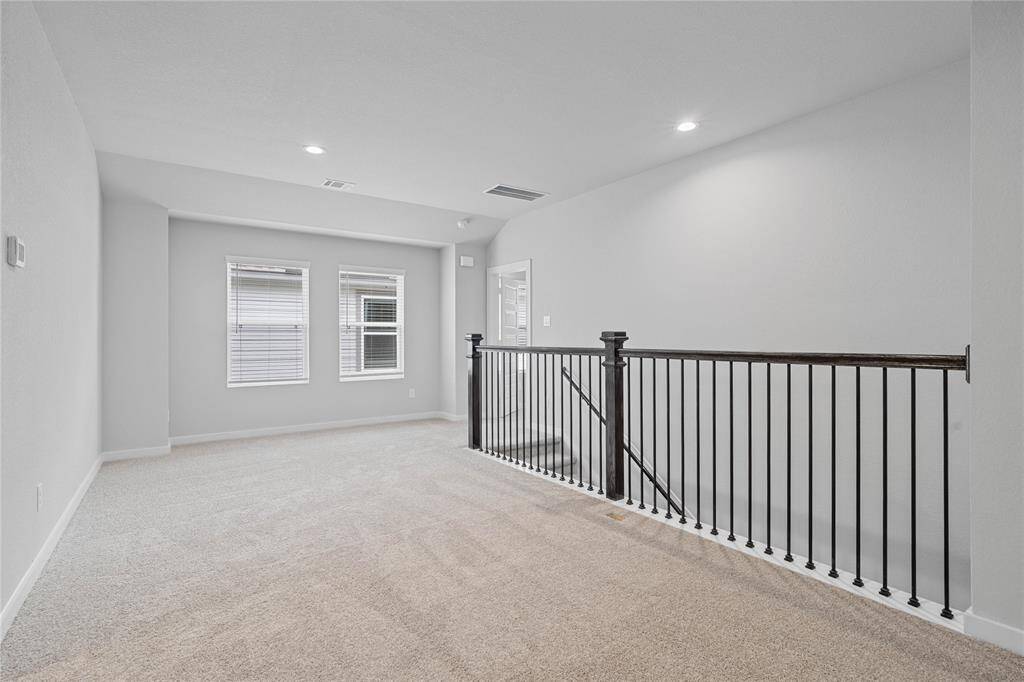 Another view of the loft area showcasing the metal balusters and windows!