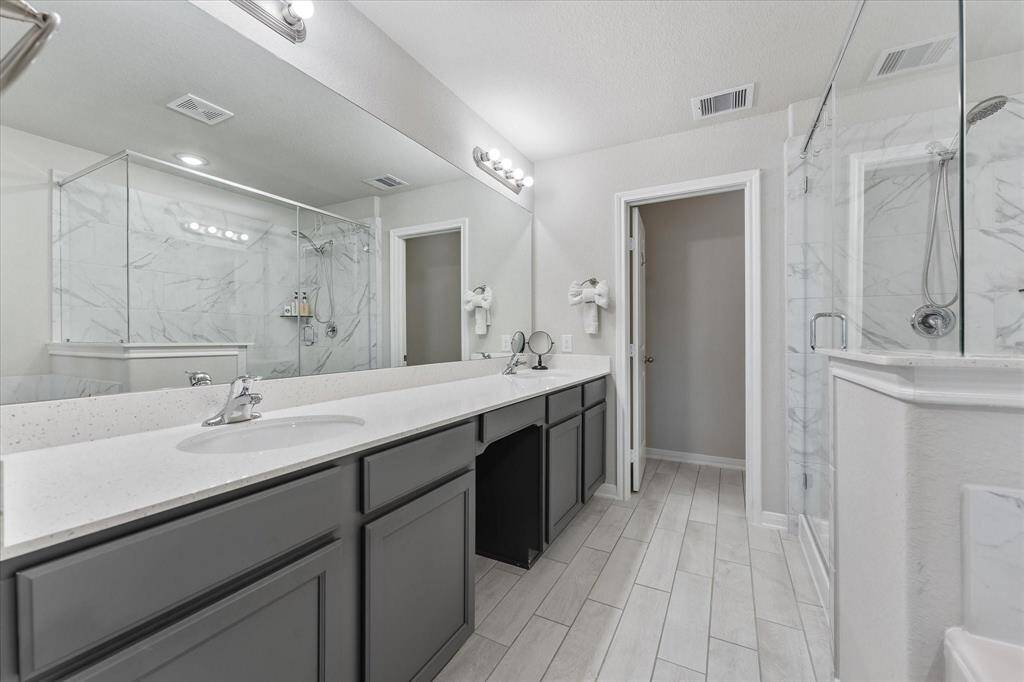 Primary bath, featuring dual sinks for added convenience, a separate shower for a refreshing start, and a luxurious soaking tub for ultimate relaxation.