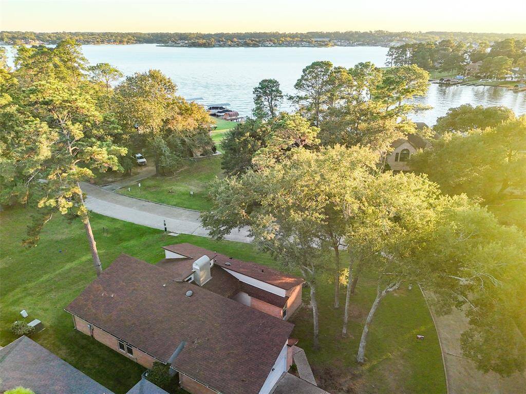 This photo shows a charming lakeview home surrounded by lush trees, offering scenic water views and a serene neighborhood atmosphere. Perfect for nature lovers seeking a peaceful retreat.