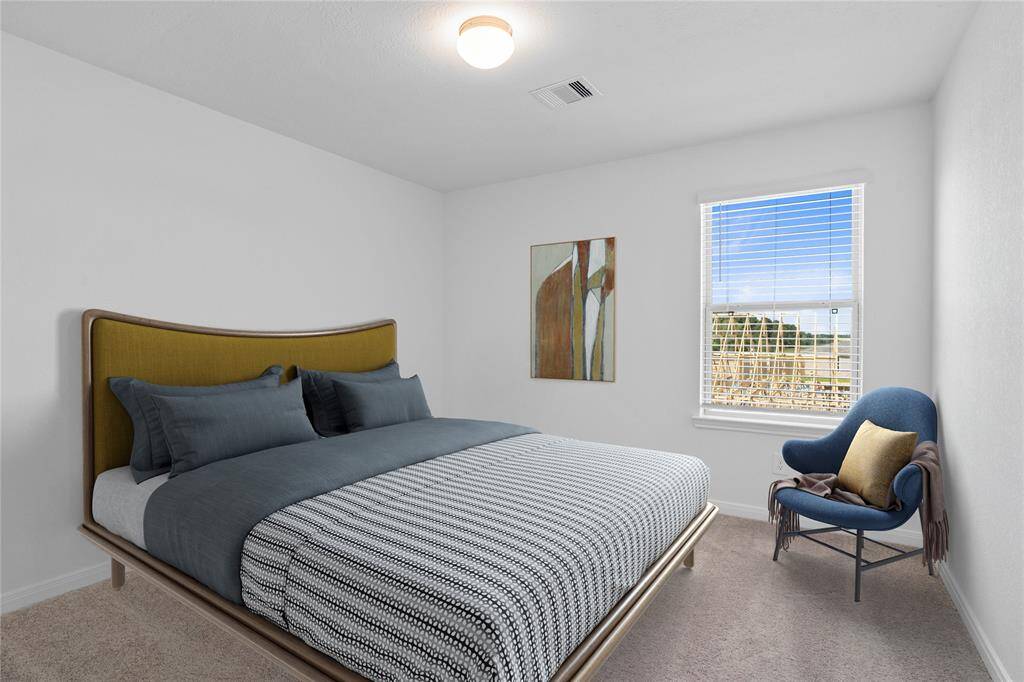 Secondary bedroom features plush carpet, neutral paint, lighting, large window, and ample sized closet space.