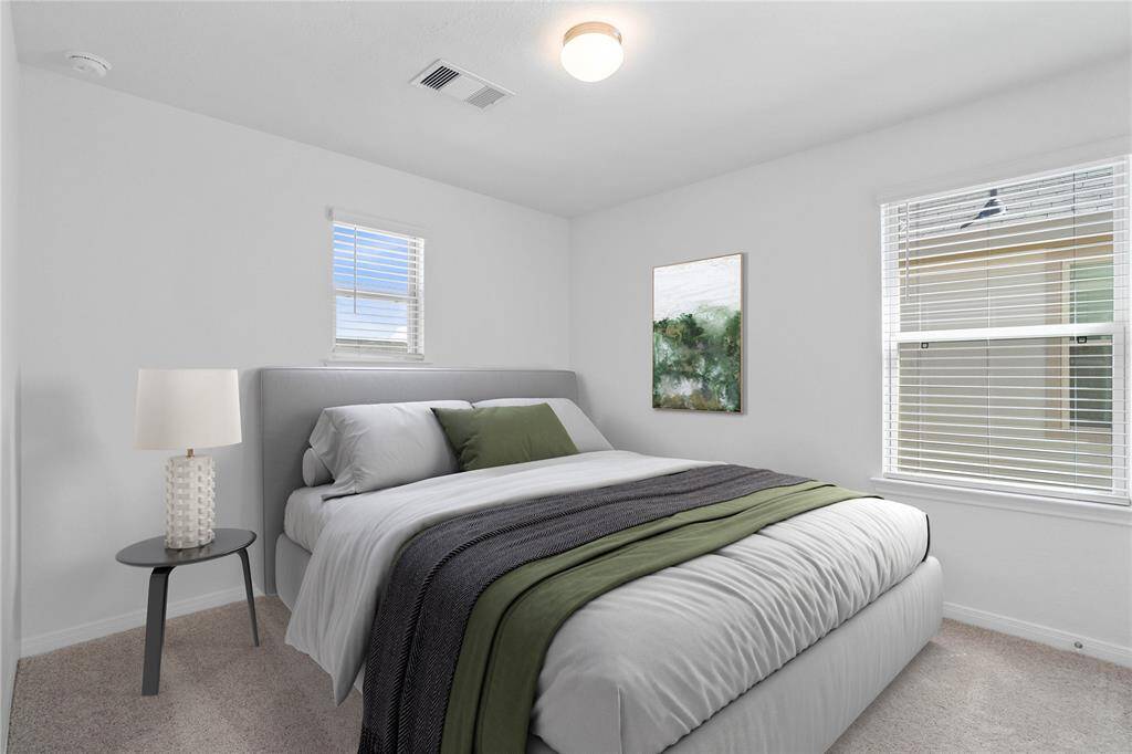Secondary bedroom features plush carpet, neutral paint, lighting, large window, and ample sized closet space.