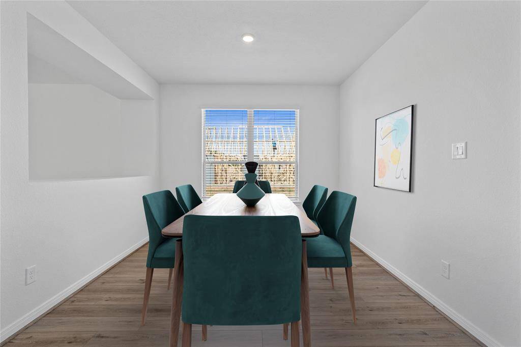This flex space is featured here as a formal dining room and is perfect for you and your guests to dine in style! This space showcases custom paint, high ceilings with recessed lighting, windows adding to the ample natural light, and vinyl plank flooring!