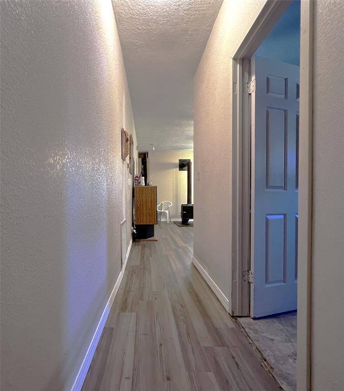 Enter the hallway to the utility room on the right and primary bedroom up ahead.