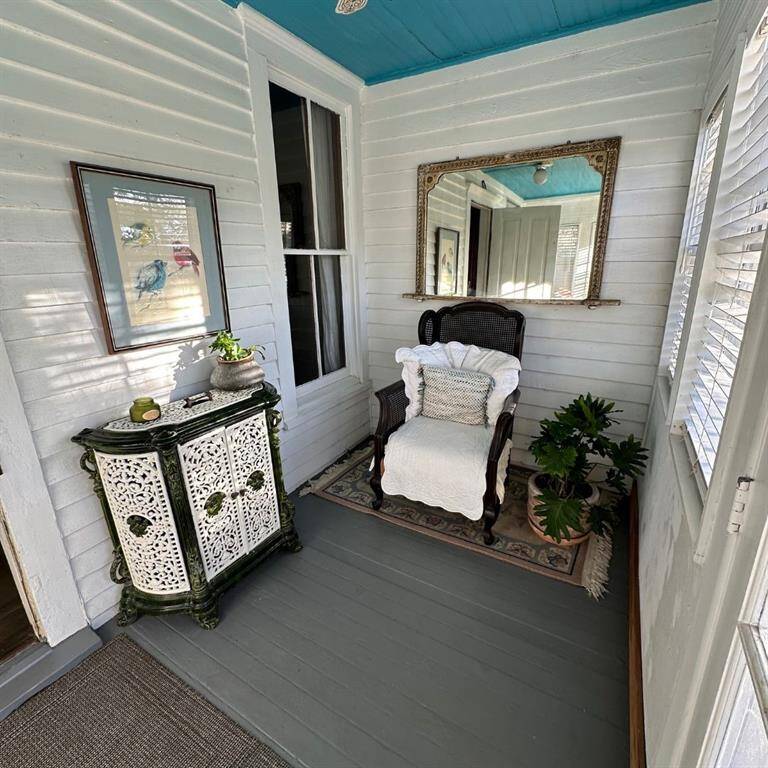 Enclosed porch overlooking side yard, perfect spot to read a book. This is one of two enclosed sunrooms.