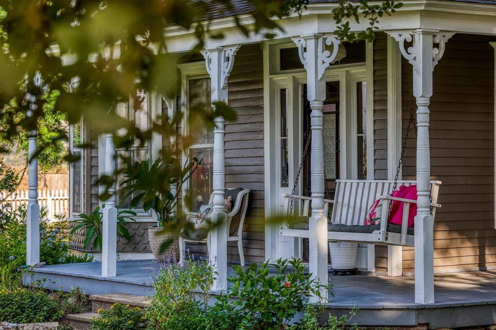Charming home featuring a cozy, covered front porch with a swing, perfect for relaxing. The porch is adorned with classic woodwork details, adding to the home's inviting curb appeal.