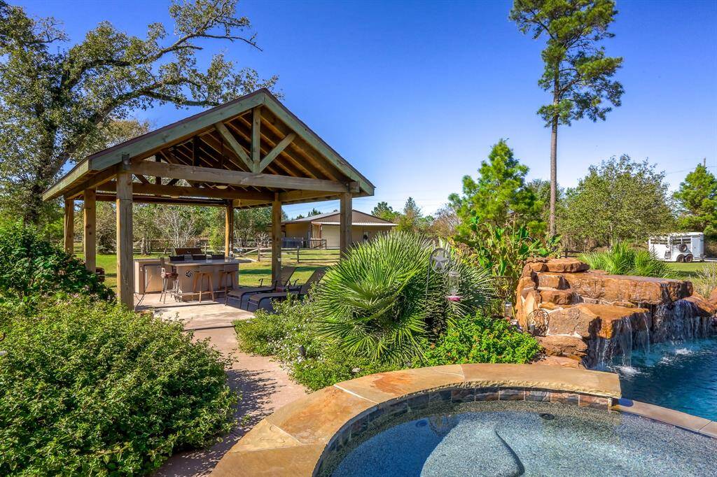 Beautiful walkway with lots of flowers that line the walkway to the outdoor kitchen