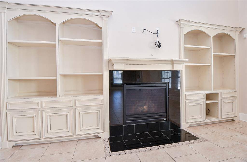 Fire place at den. Built in shelves.
