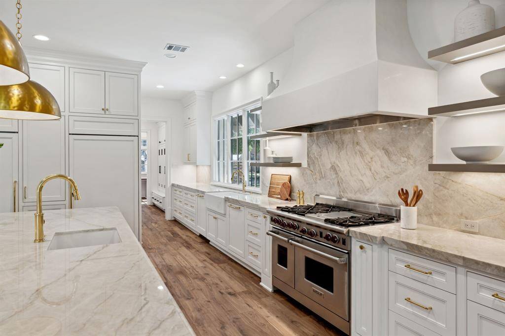 [Kitchen]  Wolf 6-burner gas range with Segreto vent hood and floating shelves are the focal point of this gourmet kitchen