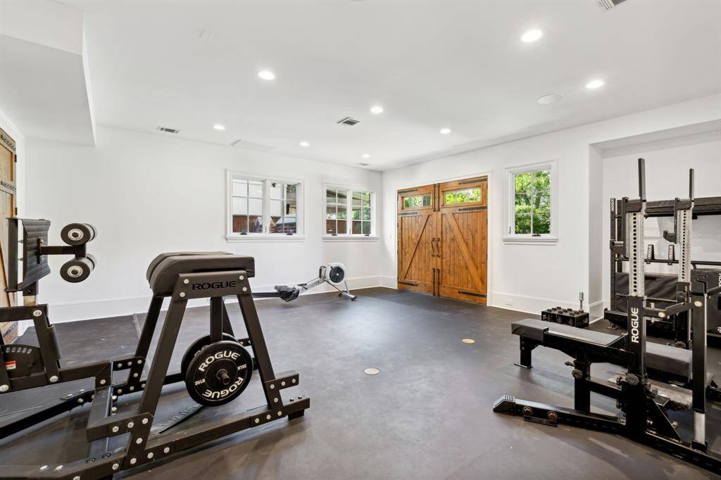 [Indoor Gym] The luxury of having your own gym and work out in the privacy of your own home.  Beautiful wooden doors access the back yard.  This space could also be additional garage parking.