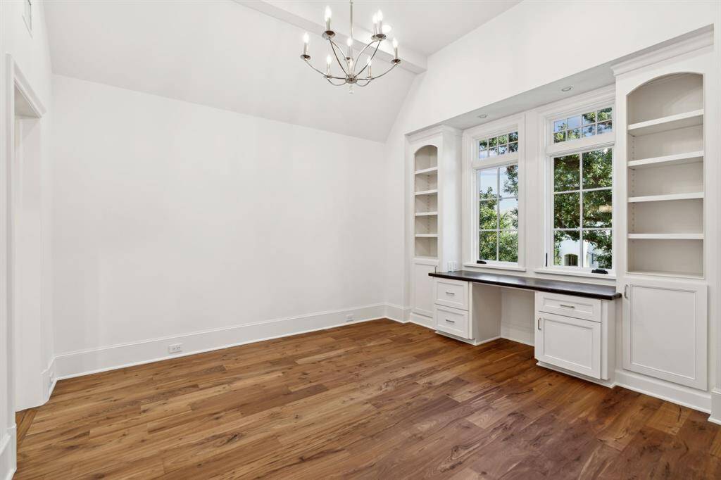 [Bedroom 1] Walnut wood floors, vaulted ceilings, built in desk and walk in closet with built ins make organizing a breeze