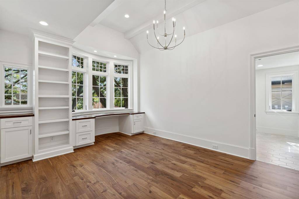 [Bedroom 2] Walnut wood floors, vaulted ceilings, built in desk and walk in closet with built ins make organizing a breeze