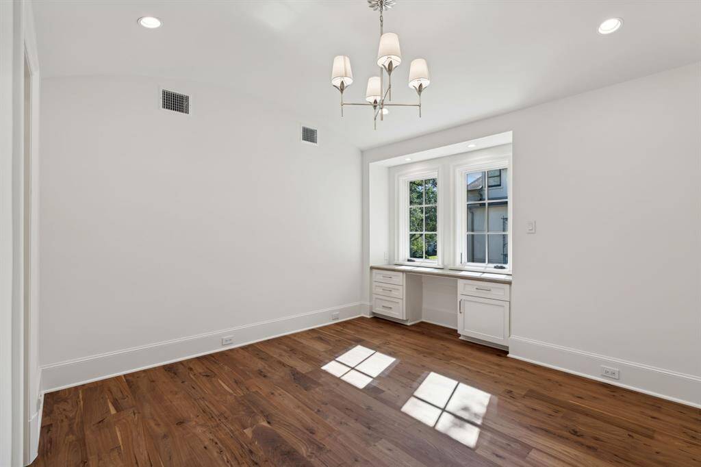 [Bedroom 3] Walnut wood floors, vaulted ceilings, built in desk and walk in closet with built ins make organizing a breeze