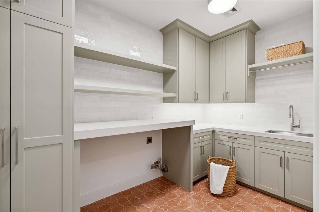[Laundry Room] Beautifully remodeled with Terracotta-colored tile flooring with a decorative pattern adds warmth and character.
