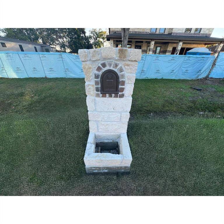 This beautiful home comes with a stone mailbox structure with a brick arch design around the mailbox door.