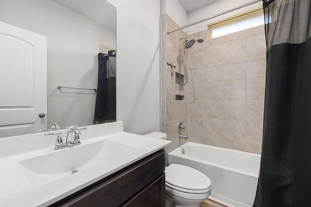 Shared bathroom between two secondary bedrooms. Notice the window above the surround in the shower.