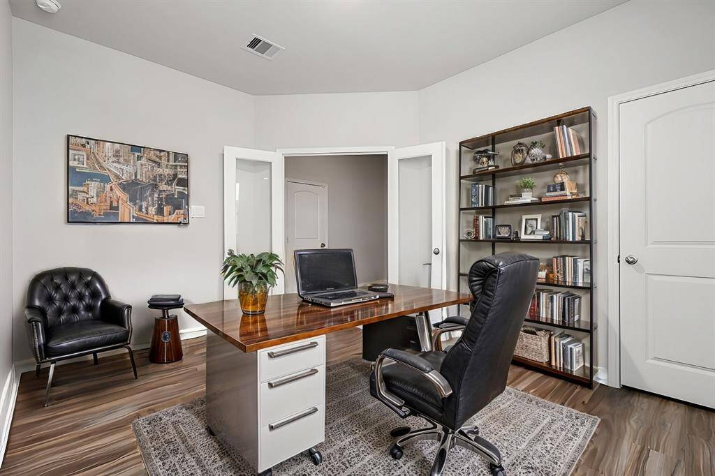 The study, which includes a closet, can serve as a fifth bedroom. It features French doors and wood-look vinyl flooring.