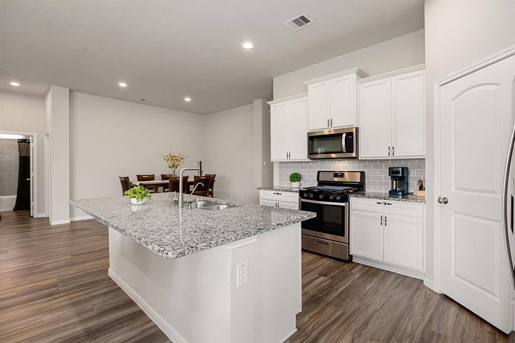 The kitchen, truly the heart of the home, won’t disappoint! It features granite countertops, a spacious walk-in pantry, and a large, functional island with seating.