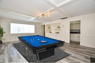 Game Room, has painted block wood paneling built in book shelves and looks into atrium