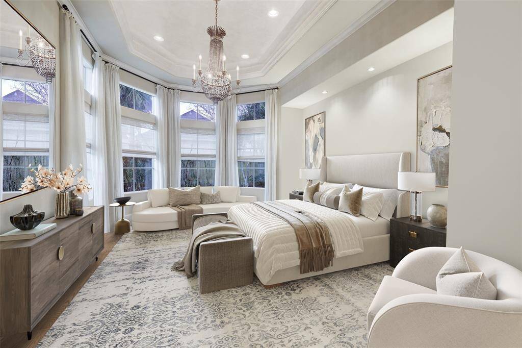 The primary suite is a masterpiece of elegance and comfort, featuring soaring ceilings, expansive floor-to-ceiling bay windows, and intricately lit moldings that create a soft, inviting glow. An ambient fireplace adds warmth and sophistication, while French doors open to a tranquil patio overlooking the koi pond, lush yard, and sparkling pools.
