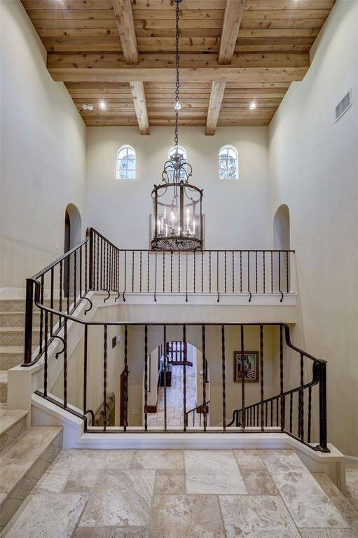 A stunning yet discreet grand staircase is a hidden architectural gem, featuring rich timber ceilings, a graceful half-level landing, and elegant clerestory windows. At its heart, a spectacular chandelier serves as a breathtaking focal point, illuminating the space with timeless charm