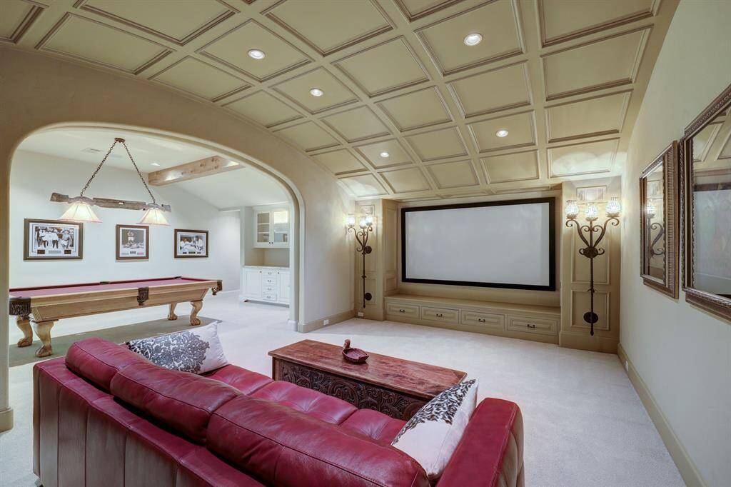 The upstairs recreation room and home theater boast elegant barreled ceilings, thoughtfully designed to enhance acoustics. This spacious and inviting area is perfect for entertainment, offering an immersive cinematic experience and a versatile space for leisure.