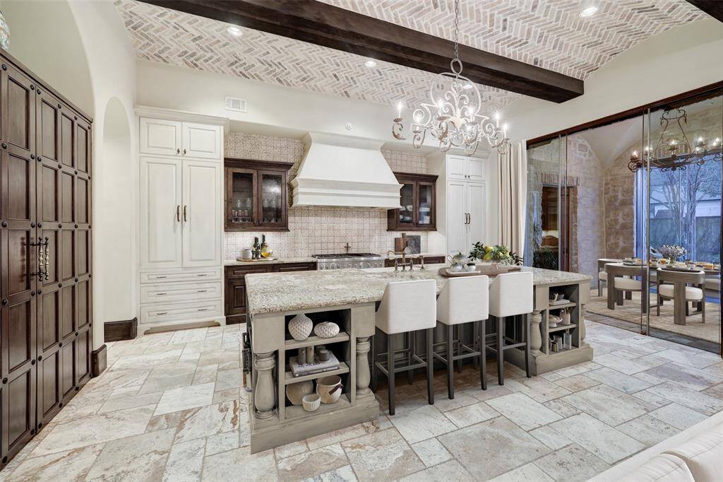 A perfect fusion of elegant Renaissance charm and natural openness, this kitchen exudes warmth and sophistication. Thoughtful details enhance its inviting atmosphere, while large windows offer stunning views of the lush yard and spacious deck. *enhanced photo