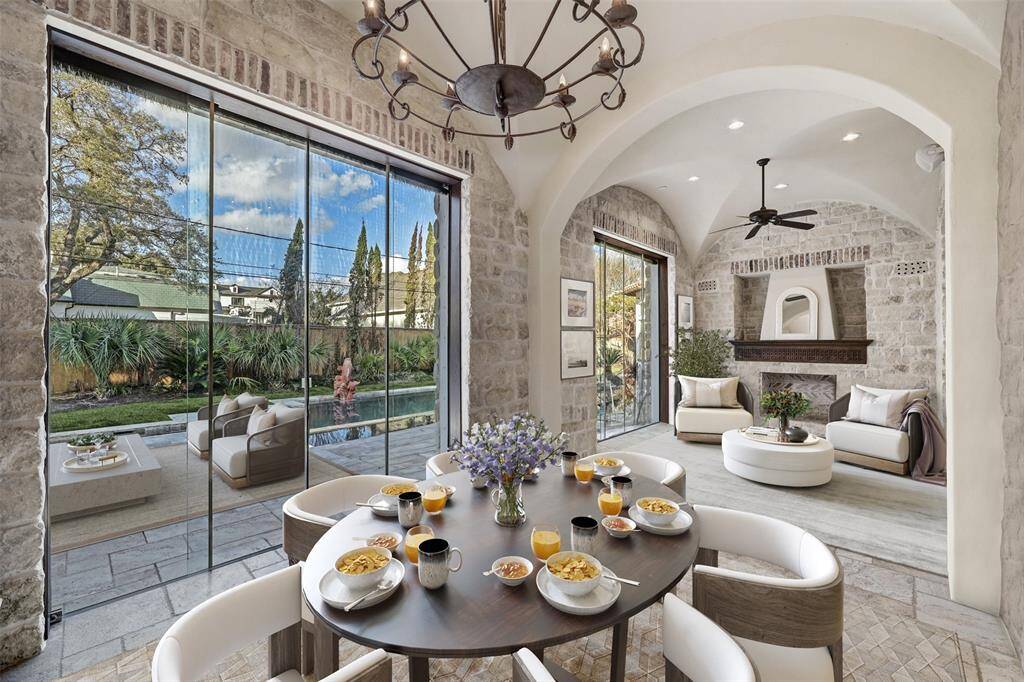 This exceptional indoor/outdoor patio offers the perfect blend of comfort and versatility. Four sets of large glass doors open to transform the space into an airy outdoor retreat or close to create a climate-controlled oasis. Featuring a covered grill, ambient fireplace, and exquisite stonework, it’s an ideal setting for year-round enjoyment. *enhanced photo