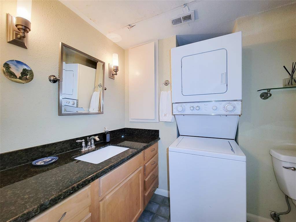 The bathroom features a shower/tub, sconce lighting, granite countertops and a handy medicine cabinet.
