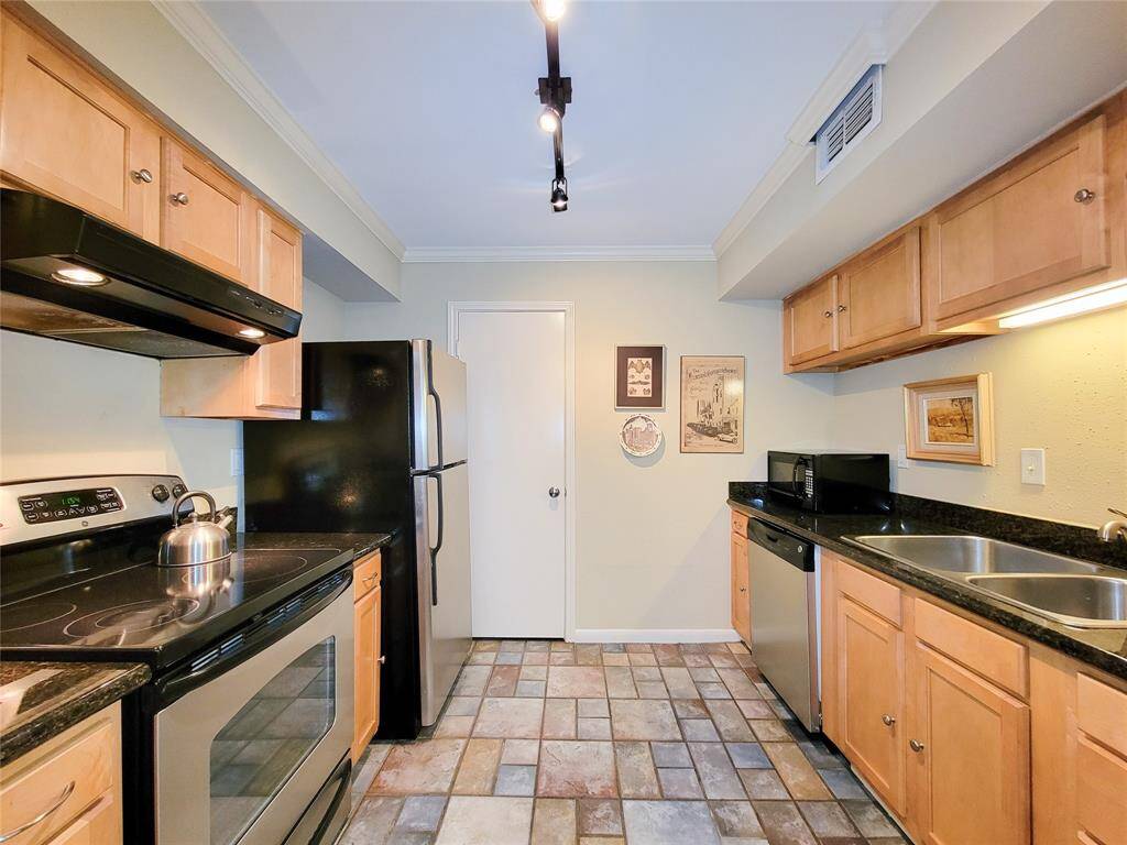 The kitchen has plenty of storage, stainless appliances and sleek black granite countertops.