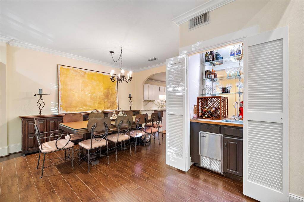 The dining area features rich hardwood floors and a built-in wet bar, offering a versatile space for casual meals and refined gatherings.