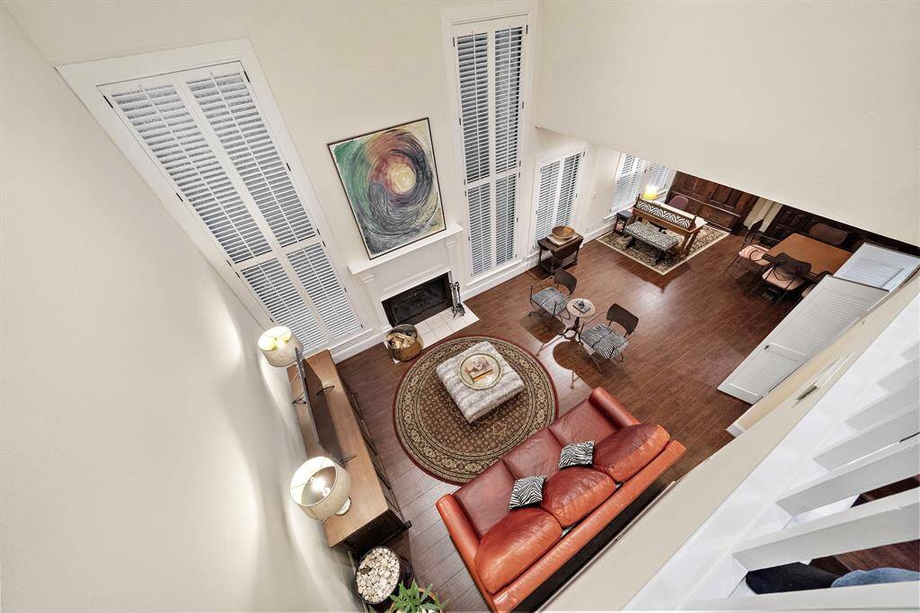 The open layout unfolds with soaring ceilings, rich wood floors, and a seamless transition between the living, dining, and entertainment spaces.