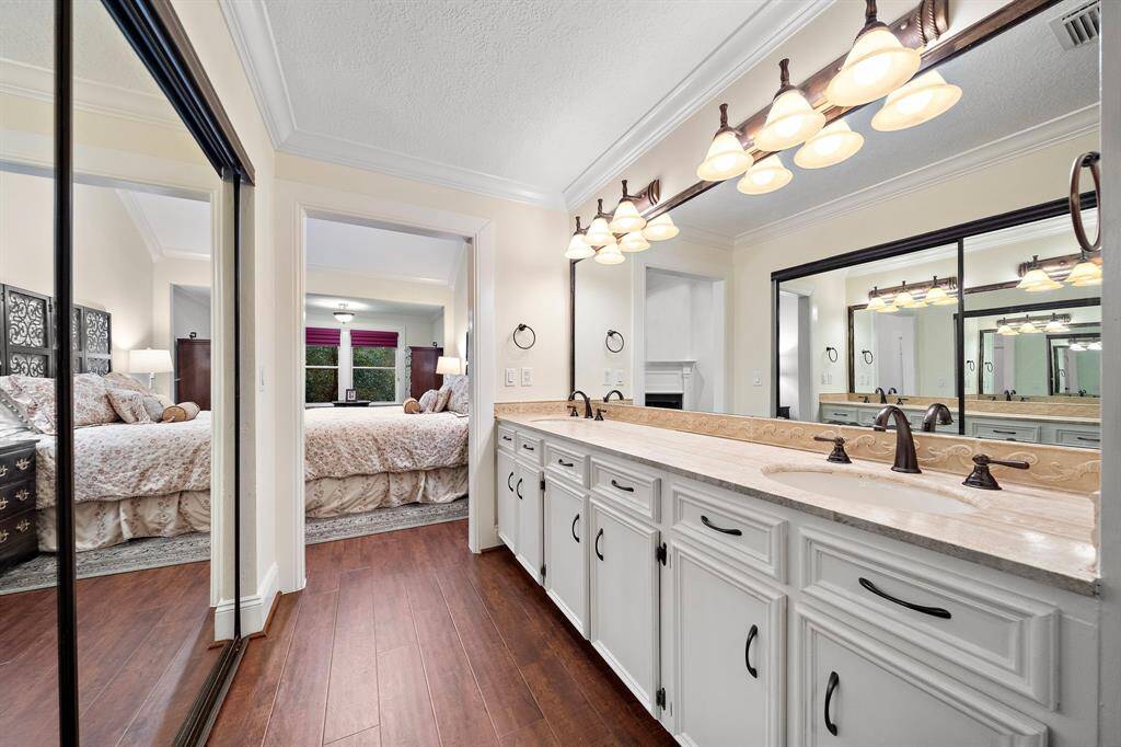 The primary ensuite bath features an expansive dual sink vanity and walls of mirrors, offering a functional space for organization and effortless daily routines.
