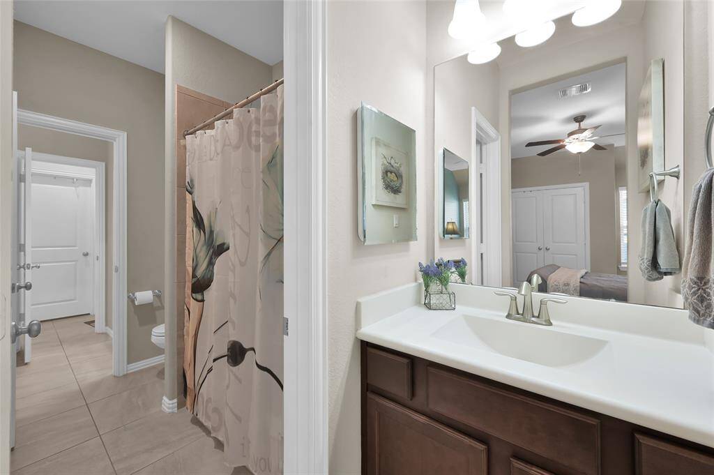 From sink area of bedroom 1, looking into shared shower and toilet area. There is another sink on the other side.  Door pictured is the laundry room